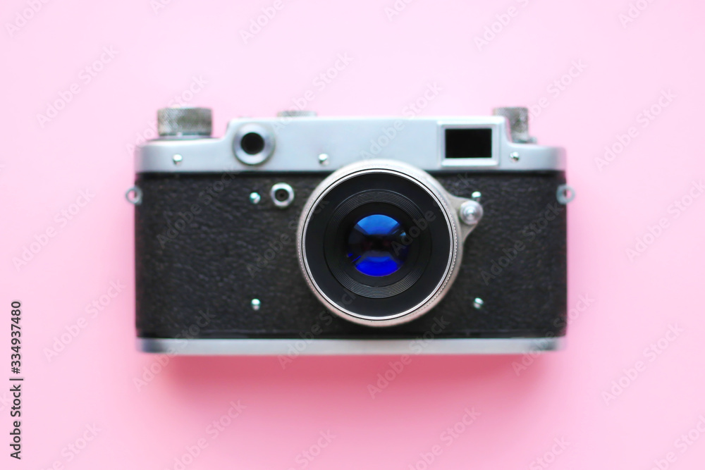 Old Retro film photo camera on a pink background. Top view, tender minimal flat lay style composition. Summer concept.