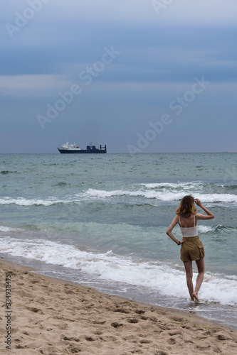  young woman on the background of the sea with a ship