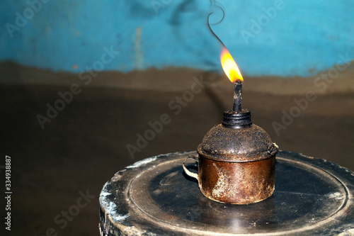 backdated or Old-fashioned oil lamp glowing in Indian village house with dark background photo