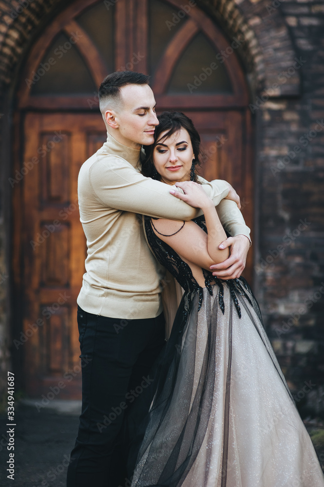 Stylish groom and sweet bride in an expensive dress are hugging against the background of an old church. Wedding portrait of lovers newlyweds. Tender photography, concept. Stylish groom and sweet bride in an expensive dress are hugging against the background of an old church. Wedding portrait of lovers newlyweds. Tender photography, concept.