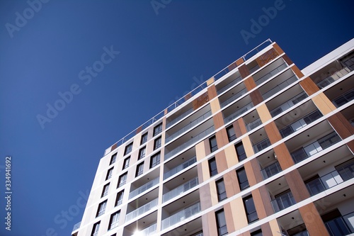 Exterior of new apartment buildings on a blue cloudy sky background. No people. Real estate business concept.