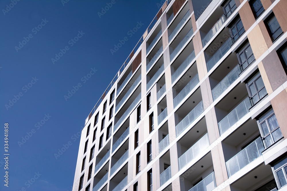 Exterior of new apartment buildings on a blue cloudy sky background. No people. Real estate business concept. Exterior of new apartment buildings on a blue cloudy sky background. No people. Real estate business concept.