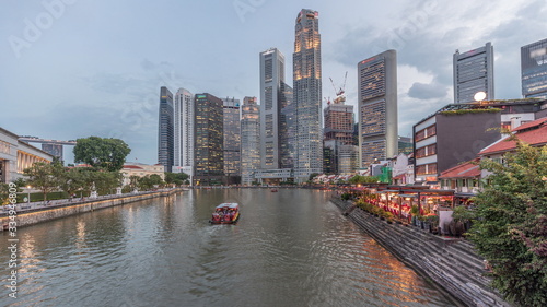 Singapore quay with tall skyscrapers in the central business district on Boat Quay day to night timelapse photo