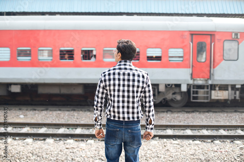 Rear view of man standing at railroad station