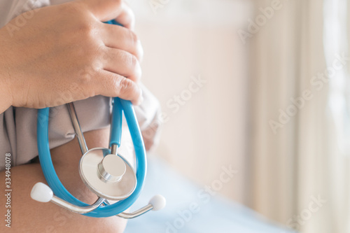 Confident Doctor with arms crossed holding stethoscope medical equipments, Medical treatment background, Stethoscope is acoustic medical device auscultation, listening to internal sounds human body