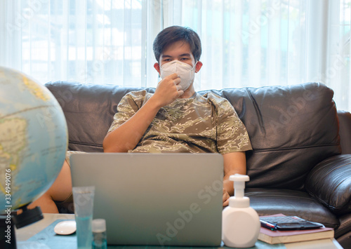 Coronavirus, Business man working from home wearing protective mask, Cleaning hands with sanitizer gel.