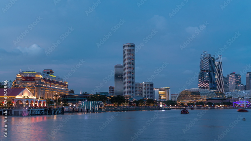 City skyline with skyscrapera and Esplanade Theatres on the Bay in Singapore at dusk, with beautiful reflection in water day to night timelapse