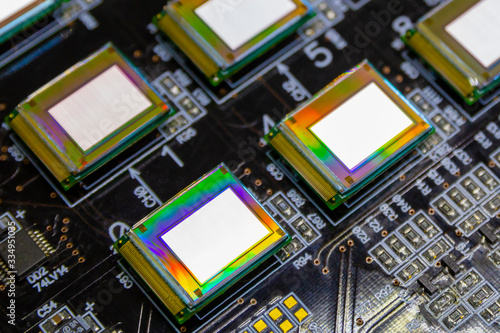 Several microdisplays bright of white color on the test station. Monitors glow brightly of white color close up.Rainbow on surface.