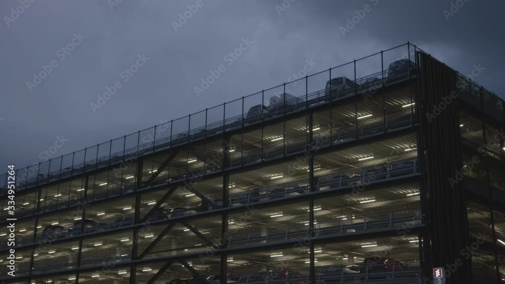 Multi Level car park with lights on against moody dark sky, Christchurch New Zealand Multi Level car park with lights on against moody dark sky, Christchurch New Zealand