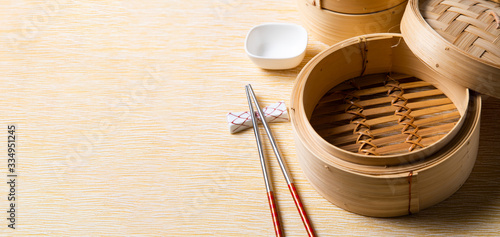 Empty basket of dim sum made by bamboo material and chopsticks. Chinese Traditional cuisine concept. Dumplings Dim Sum in bamboo steamer with text copy space. Asian food background