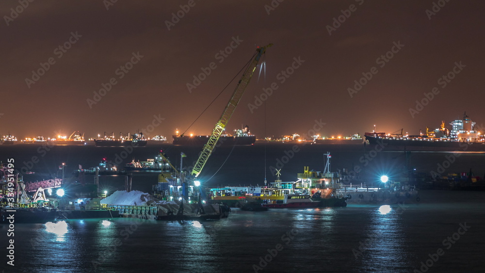 Singapore Marina Barrage with cargo ships waiting to enter one of the busiest ports in the world night timelapse, Singapore. Singapore Marina Barrage with cargo ships waiting to enter one of the busiest ports in the world night timelapse, Singapore.