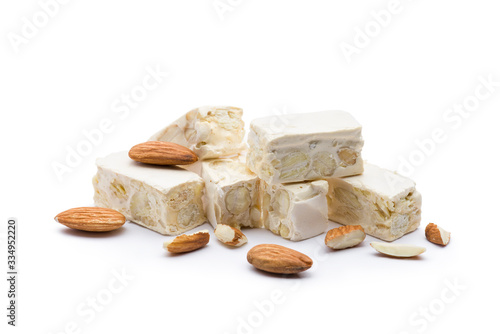 small nougat pieces with almonds, on white background. photo