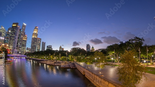 Singapore skyscrapers skyline with white Anderson Bridge near esplanade park day to night timelapse.