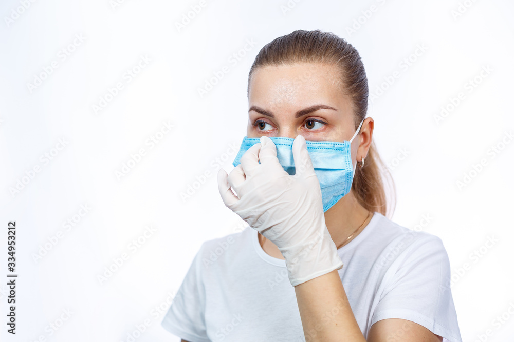 woman health worker demonstrates how to wear a protective medical surgical mask against the virus. Isolated on white background woman health worker demonstrates how to wear a protective medical surgical mask against the virus. Isolated on white background