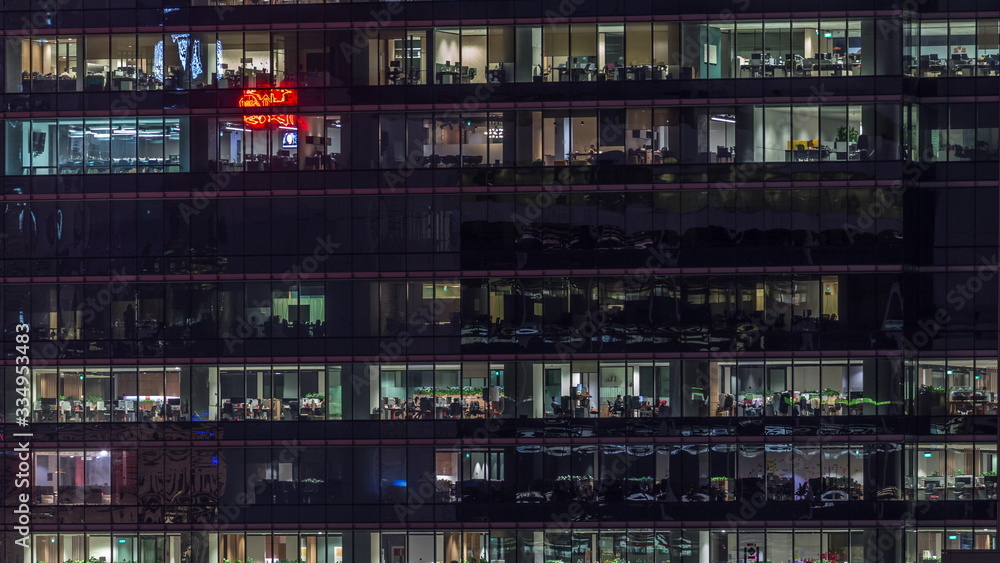 Modern office building with big windows at night timelapse, in windows light shines