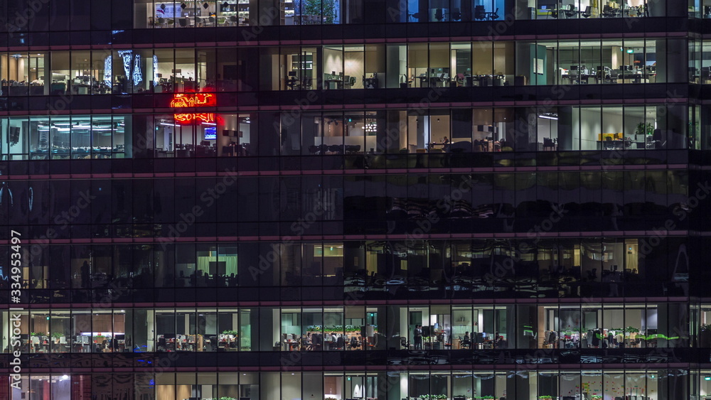 Modern office building with big windows at night timelapse, in windows light shines