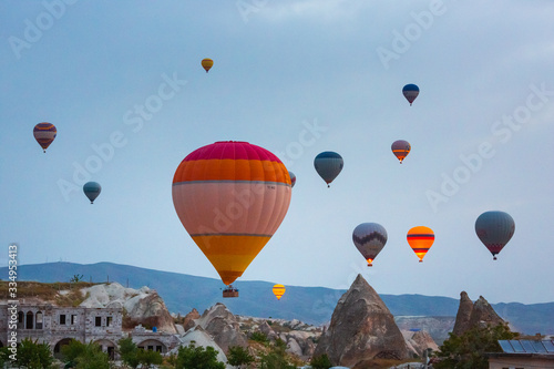 Baloons on the sky and typical Cappadocian landscape, close to Goreme. Nevsehir, Anatolia, Turkey