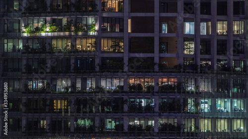 Modern office building with big windows at night timelapse  in windows light shines