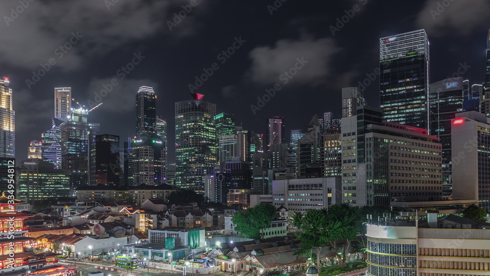The Buddha Tooth Relic Temple comes alive at night timelapse in Singapore Chinatown, with the city skyline in the background.