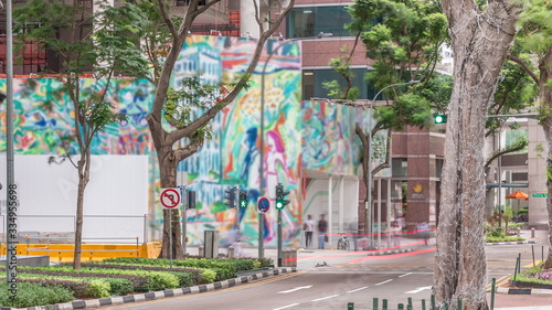 Battery Road avenue with traffic and surrounded by green trees in downtown timelapse, Singapore photo