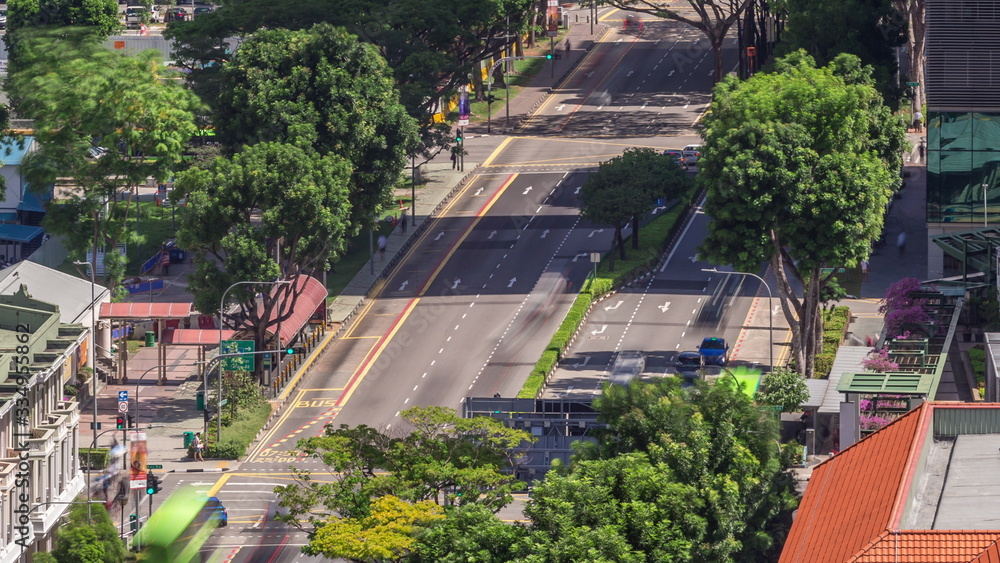 Fototapeta premium Traffic with cars on a street and urban scene in the central district of Singapore timelapse