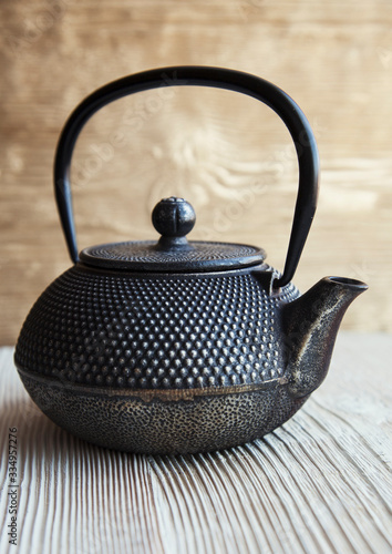 Close up black metall tea pot on a wooden background