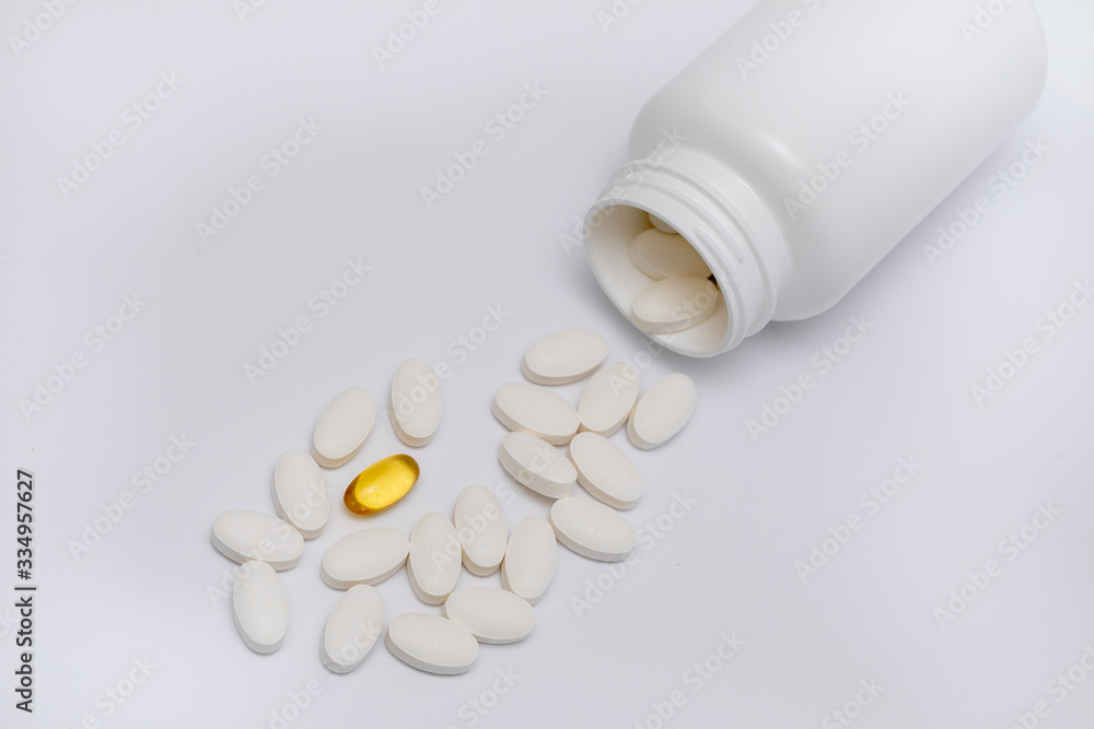 White round tablets covered with a cover are scattered from a plastic can with them. Drugs, pill. White round tablets covered with a cover are scattered from a plastic can with them. Drugs, pill.