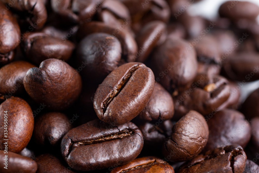 A macro closeup view of a mound of dark roasted coffee beans. A macro closeup view of a mound of dark roasted coffee beans.