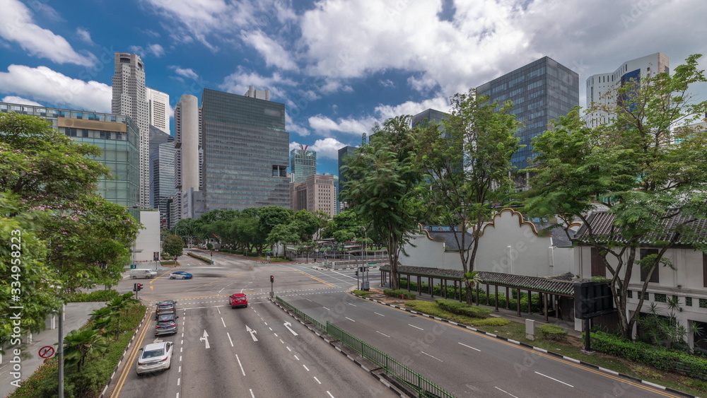 Obraz premium Traffic with cars on a street and urban scene in the central district of Singapore timelapse