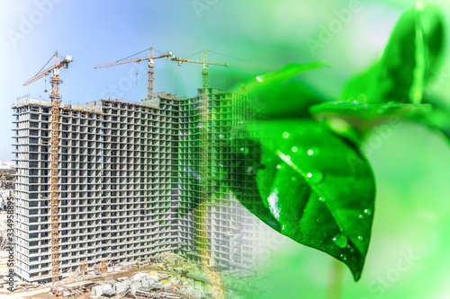 	Green leaves on the background of residential building construction . Concept of environmental protection .