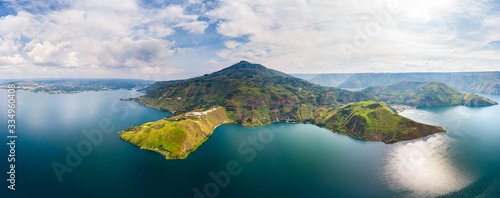 Aerial: lake Toba and Samosir Island view from above Sumatra Indonesia. Huge volcanic caldera covered by water, traditional Batak villages, green rice paddies, equatorial forest. photo
