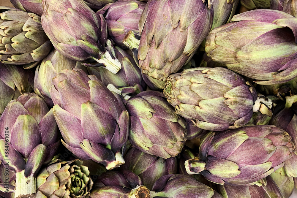 Heap of ripe fresh artichokes in the market counter. Vegetables background texture. Advertisement backdrop Heap of ripe fresh artichokes in the market counter. Vegetables background texture. Advertisement backdrop
