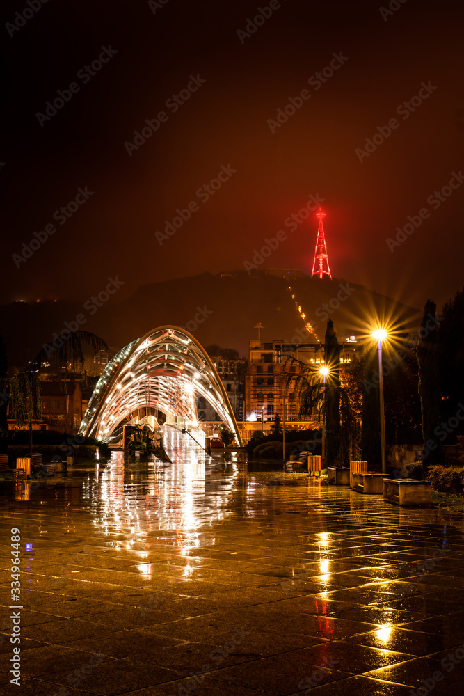 Rike park pathway at night with peace bridge and illiuminated Tv tower in the background. Tbilisi. Georgia. 25.03.2020