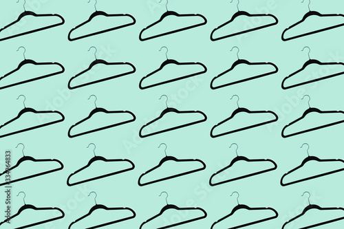 Pattern of black hangers isolated on background of aqua menthe color.