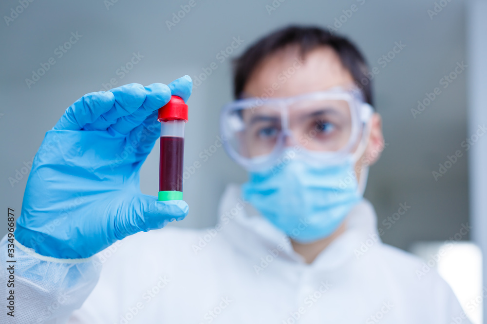Coronavirus Covid 19 infected blood sample in sample tube in hand of scientist doctor biohazard protection clothing in coronavirus covid 19 research laboratory, Coronavirus Covid-19 vaccine research Coronavirus Covid 19 infected blood sample in sample tube in hand of scientist doctor biohazard protection clothing in coronavirus covid 19 research laboratory, Coronavirus Covid-19 vaccine research