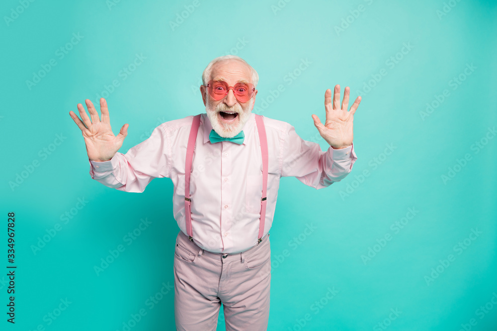 Naklejka premium Hey-hey its me. Portrait of positive cheerful old man true hipster raise hands greet his retired friends family scream wear good looking outfit isolated over green color background