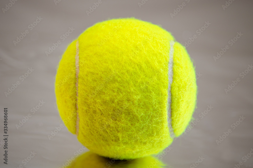 green tennis ball with deep bokeh on a silver background
