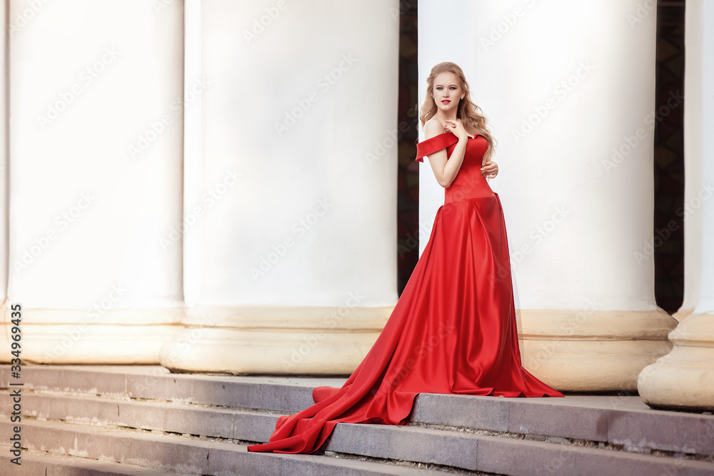 Beautiful blonde girl in a red long dress on a background of architecture, columns Beautiful blonde girl in a red long dress on a background of architecture, columns