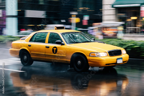 Yellow taxi driving through the streets of New York on a rainy day. Dynamic image