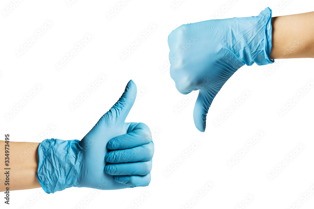 Hands in a medical glove show thumb up down . On a white isolated background Hands in a medical glove show thumb up down . On a white isolated background