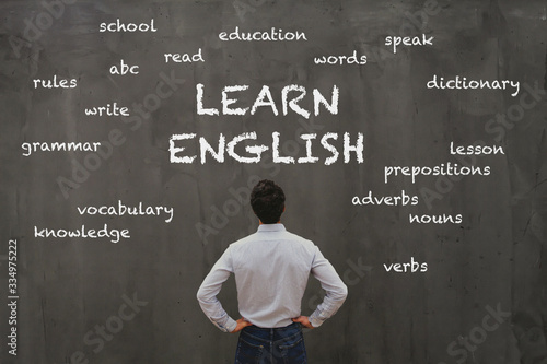 learn english concept, business man looking at word cloud on chalk board photo