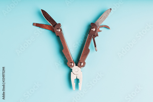 The multitool multi-function tool hovers on a blue background. The concept of an expanded multi-tool with free space.