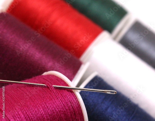 A macro photograph of sewing bobbins and a needle. Close up photograph, colorful hobby concept.