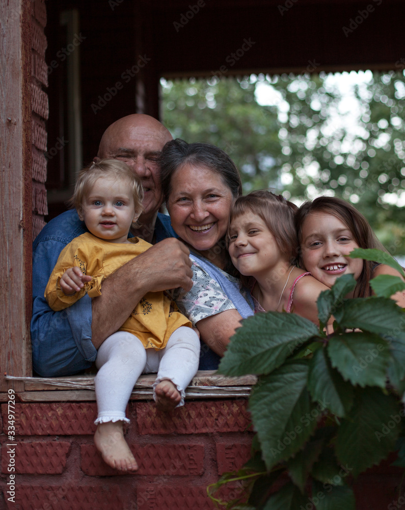 grandparents hugging granddaughters on verandah grandparents hugging granddaughters on verandah