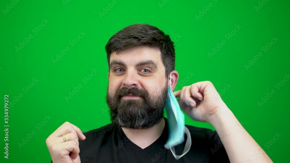 A bearded man in a mask smears his hands with an antiseptic and jokes