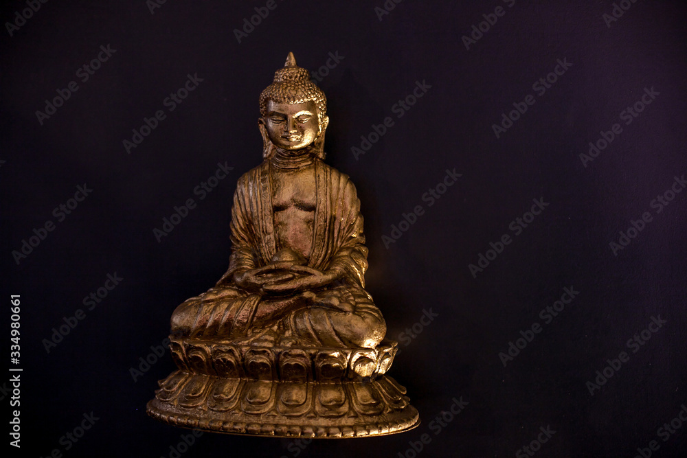 small figurine of Buddha on a black