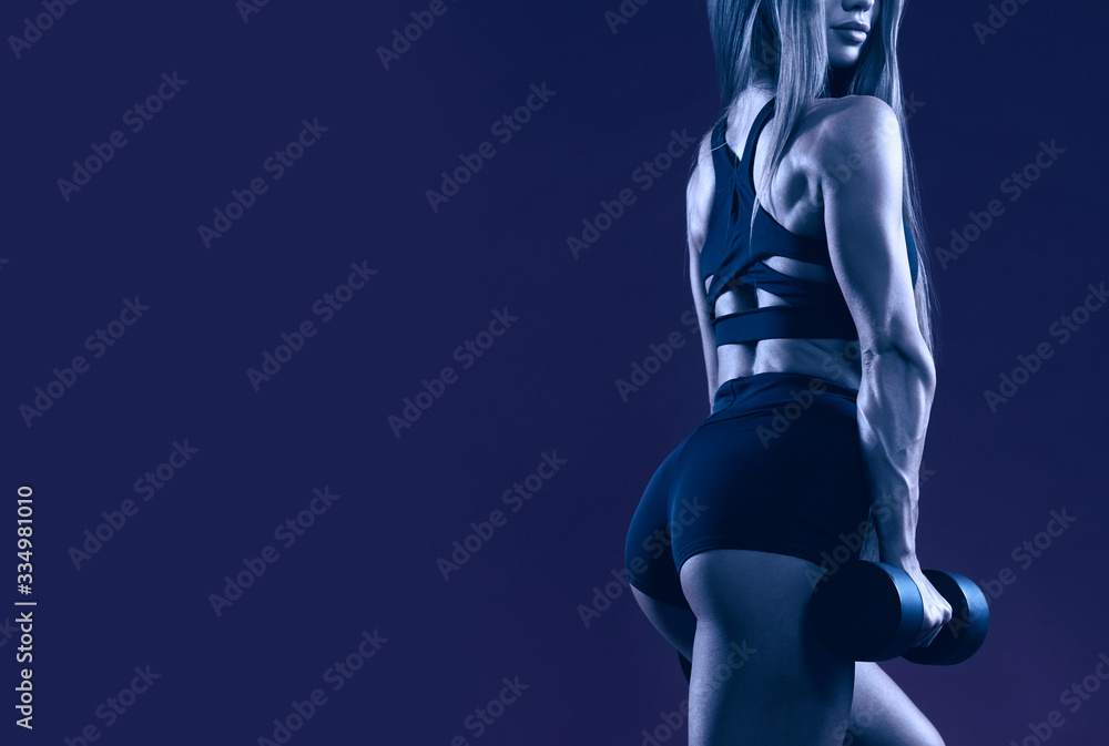 Blue crop of sportswoman holding dumbbell. Blue crop of sportswoman holding dumbbell.