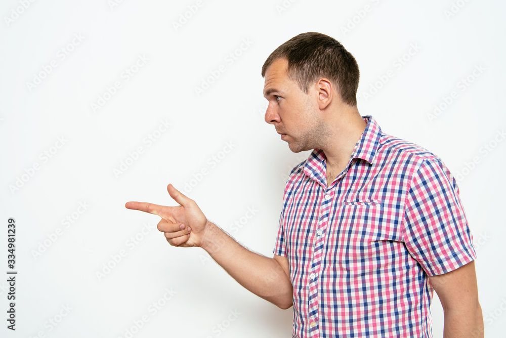 Closeup side view portrait of young man, pointing with finger at someone or something. Closeup side view portrait of young man, pointing with finger at someone or something.