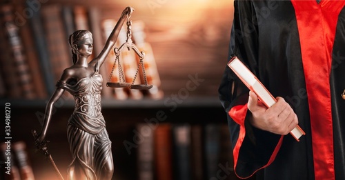 Фотография The judge in judicial gown with book and Femida statue