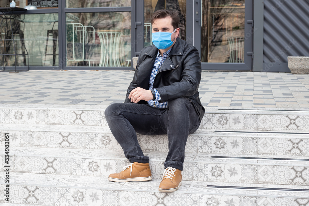 man sitting in mask in urban background man sitting in mask in urban background